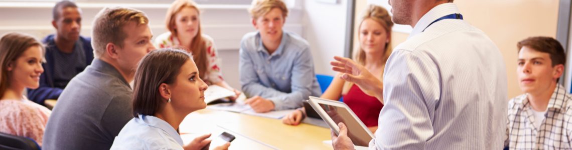 Teacher,With,College,Students,Giving,Lesson,In,Classroom